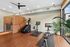 Contemporary fitness area featuring an advanced step machine, modern exercise bike, sleek rowing machine, and a stylish sauna room with natural light.