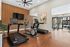 Modern fitness center with sleek treadmills, stationary bike, and pool view offering a vibrant workout environment.