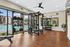 Luxurious apartment gym with modern equipment and a stunning pool view, perfect for fitness enthusiasts.
