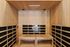 Luxurious wooden sauna room with modern lighting and comfortable seating for ultimate relaxation.