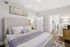 Inviting bedroom with a plush king-sized bed, elegant decor, and warm lighting, ideal for relaxation and comfort.