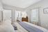 Bright and cozy bedroom showcasing elegant decor, spacious layout, and natural light streaming through stylish curtains.