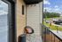 Charming balcony view featuring cozy seating with a vibrant cushion, overlooking a serene residential setting.
