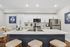 Elegant modern kitchen with sleek white cabinetry, stainless steel appliances, and a large marble island with bar seating, perfect for entertaining.