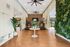 Modern fitness room with treadmills, vibrant green wall, and lush indoor plants creating a refreshing atmosphere.