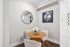 Chic dining nook with a round wooden table, elegant white chairs, and floral decor creating a cozy ambiance.