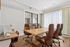 Bright and sophisticated conference room with elegant brown leather chairs, a large wooden table, and abundant natural light from floor-to-ceiling windows.