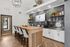 Chic and modern communal kitchen area with sleek countertops, elegant bar seating, and stylish pendant lighting, perfect for social gatherings.