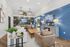 Chic communal lounge with stylish decor, featuring modern lighting, a vibrant blue accent wall, and comfortable seating perfect for relaxation.