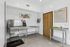 Modern pet grooming station with stainless steel facilities, vibrant dog artwork, and sleek design.