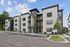 Modern apartment complex featuring sleek architecture, spacious balconies, and convenient parking with lush greenery in the foreground.