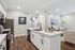 Chic open-concept kitchen and living area featuring sleek white cabinetry, modern appliances, and inviting decor for a stylish living experience.