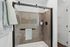 Modern bathroom featuring a sleek glass shower with elegant dark fixtures and plush towels in a serene setting.