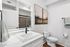 Elegant bathroom with modern fixtures, sleek vanity, and stylish artwork on the wall complementing a serene atmosphere.