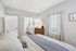 Inviting bedroom with elegant decor, large windows, and direct access to a modern en suite bathroom.