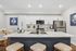 Sleek modern kitchen with white cabinetry, stainless steel appliances, and elegant island seating, perfect for entertaining.