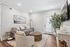 Inviting and modern living room with chic decor, plush gray sofa, stylish wicker coffee table, and lush indoor plant accent.