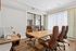 Sophisticated home office with sleek conference table, leather chairs, and warm wood flooring, offering a bright and airy atmosphere.