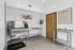 Modern pet spa room with stainless steel washing station, bright artwork, and convenient facilities.