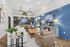 Chic, contemporary living room with elegant decor, featuring a stylish blue accent wall, cozy seating, and modern lighting fixtures.
