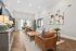 Inviting living room with elegant hardwood flooring, plush seating, modern decor, and large windows offering abundant natural light and a scenic view.