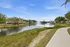 Serene apartment setting with tranquil pond view, fountains, and lush greenery along a scenic walking path.