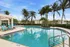 Luxurious pool area with palm trees and comfortable sun loungers, perfect for relaxation and leisure.