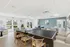 Bright and inviting recreation room with a modern ping pong table, comfortable seating, and large windows offering serene garden views.