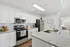 Modern kitchen with sleek granite countertops, stainless steel appliances, and stylish white cabinetry for a contemporary living experience.