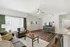 Bright and spacious living room with elegant decor, featuring a cozy seating area, stylish wooden flooring, and modern entertainment unit.