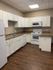 Bright and modern kitchen with white cabinetry, sleek countertops, and high-end appliances.
