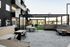 Modern outdoor communal area featuring elegant patio seating, stylish pergolas, and lush greenery for relaxation and social gatherings.