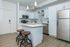Modern kitchen with sleek white cabinetry, stainless steel appliances, and elegant island seating.
