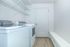 Sleek and modern laundry room with energy-efficient washer and dryer, featuring ample shelving and storage space.