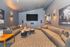 Modern entertainment room with plush seating, ambient lighting, and wall-mounted TV, perfect for movie nights.