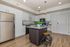 Modern kitchen with sleek appliances, white cabinetry, and a spacious granite island complemented by stylish pendant lighting.