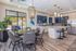 Bright and modern kitchen with elegant lighting, sleek appliances, and stylish dining area featuring lush greenery and outdoor views.