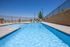 Inviting outdoor pool with clear blue water, surrounded by scenic views and lounge chairs for relaxation.