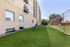 Inviting apartment exterior featuring a well-maintained green lawn and modern architecture, perfect for outdoor relaxation.