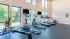 Bightly-lit fitness room with bright walls and rubber gym floor featuring top-class cardio equipment