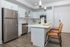 Modern kitchen featuring sleek white cabinets, stainless steel appliances, and elegant hardwood floors.