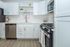 Modern kitchen featuring sleek white cabinets, stainless steel appliances, and elegant hardwood floors.