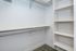 Spacious walk-in closet with a clean, modern design, featuring built-in shelving and ample hanging space for easy organization.