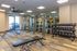 Modern fitness center with state-of-the-art equipment, sleek mirrored walls, and ample natural light offering a vibrant workout experience.