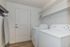 Bright and functional laundry room with modern washer and dryer, sleek shelving, and ample storage space.