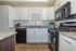 Modern kitchen with sleek white cabinets, granite countertops, and stainless steel appliances, offering style and functionality.