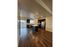 Modern open kitchen with sleek stainless steel appliances, dark wood cabinets, and an inviting breakfast bar against a backdrop of rich hardwood floors and ample natural light.