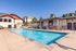 Inviting outdoor pool area with elegant fountains and modern clubhouse, ideal for relaxation and leisure.