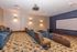 Luxurious home theater room with plush seating, elegant wall sconces, and a spacious screen, perfect for cinematic experiences.