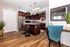 Modern kitchen with sleek dark wood cabinets, stainless steel appliances, and a stylish island with bar seating. Elegant decor and bright wood flooring enhance the ambiance.